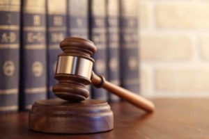 Image of a gavel on a desk in front of legal books