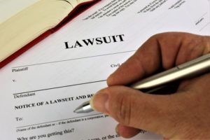 Image of a lawyer filling out paperwork titled lawsuit